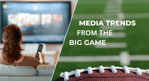 Person watching the Super Bowl on a TV screen showing a football play.